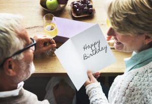 A wife reads a happy birthday card from her husband