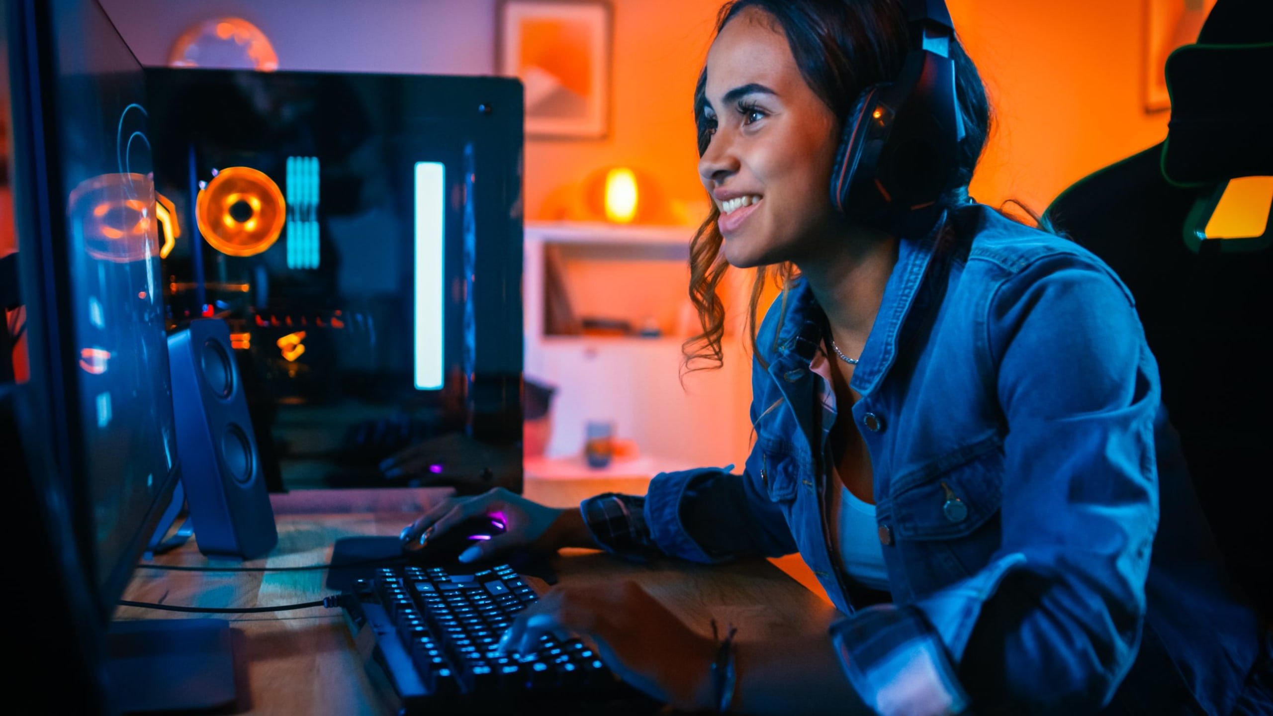 A young girl wearing headphones and playing online video games