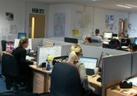 A picture of our information and advise team working at their desks.