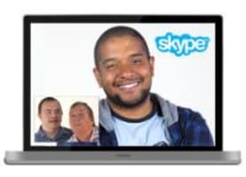 Image of a laptop showing a man using Skype to video call with two other men