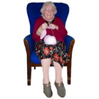 A photo  of an elderly lady siting in a chair.